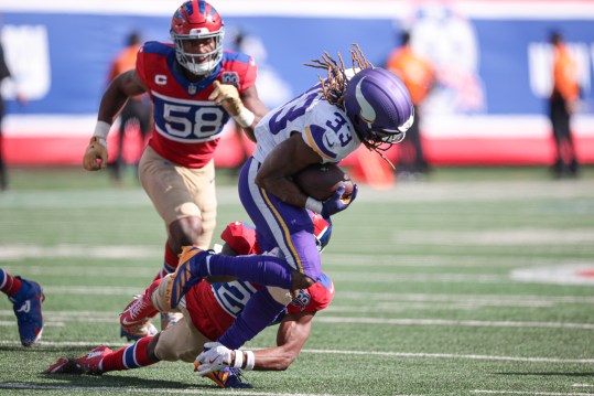 Sep 8, 2024; East Rutherford, New Jersey, USA; Minnesota Vikings running back Aaron Jones (33) fights for yards as New York Giants cornerback Dru Phillips (22) tackles during the second half at MetLife Stadium. Mandatory Credit: Vincent Carchietta-Imagn Images