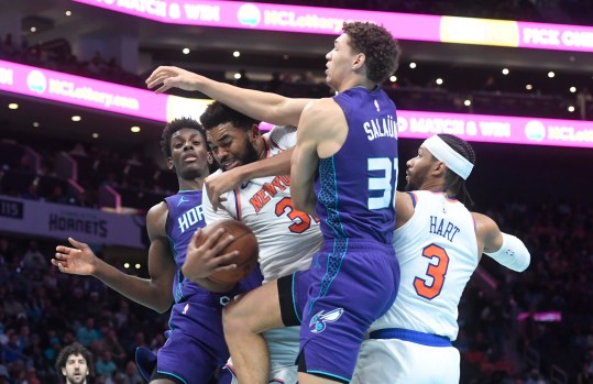 Nov 29, 2024; Charlotte, North Carolina, USA; New York Knicks center Karl-Anthony Towns (32) gets a rebound from Charlotte Hornets forward Tidjane Salaun (31) during the second half at the Spectrum Center. Mandatory Credit: Sam Sharpe-Imagn Images