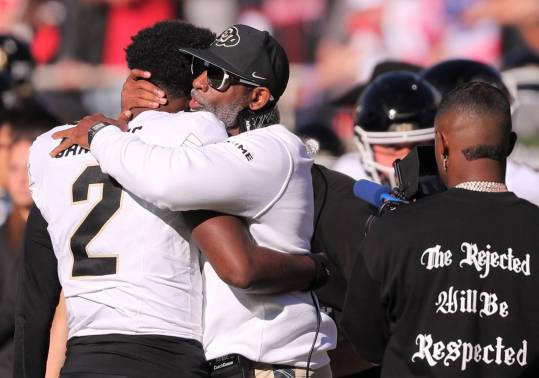 Colorado football coach Deion Sanders hugs his son, Shedeur Sanders, before facing Texas Tech in a Big 12 football game Saturday, Nov. 9, 2024, at Jones AT&T Stadium.