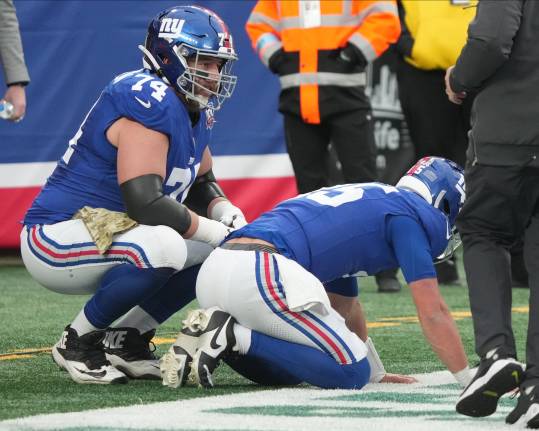 East Rutherford, NJ -- November 24, 2024 -- Tommy DeVito of the Giants gets hit by Calijah Kancey of Tampa Bay after he threw a pass in the fourth quarter. DeVito was injured and came out of the game for one play as the Tampa Bay Buccaneers came to MetLife Stadium and defeated the New York Giants 30-7.