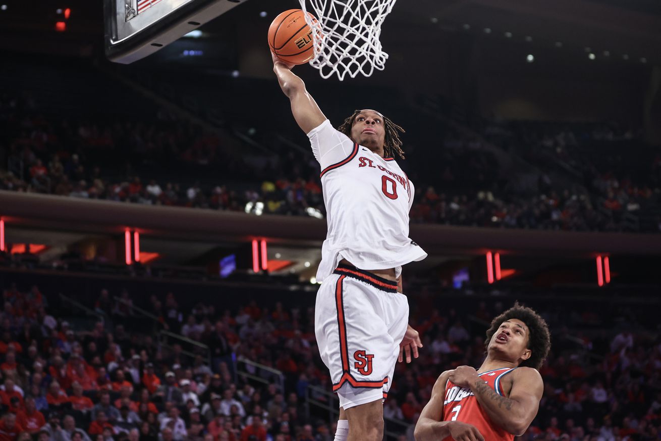 New York, New York, USA; St. John’s Red Storm guard Aaron Scott (0) drives past New Mexico Lobos guard Tru Washington (3) for a dunk in the second half at Madison Square Garden. Mandatory Credit: Wendell Cruz-Imagn Images