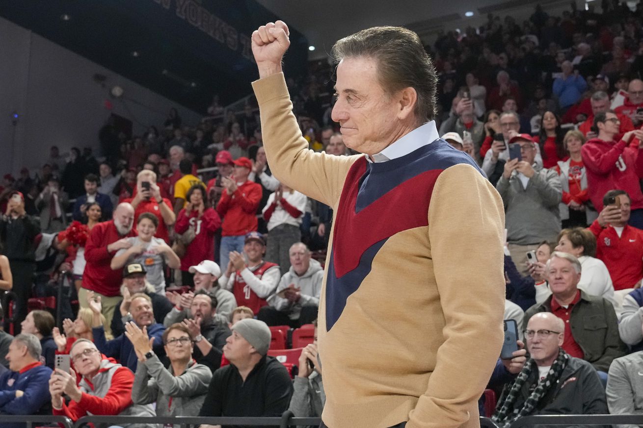  NEW YORK, NY - DECEMBER 7: Head coach Rick Pitino of the St. John’s Red Storm reacts to the crowd while wearing a sweater to honor long-time Red Storm coach Lou Carnesecca, who died Nov. 30, before Big 12/Big East Battle game against the Kansas State Wildcats at Carnesecca Arena on December 7, 2024 in the Queens borough of New York, New York. Carnesecca wore a similar sweater while on a win streak in 1985. St. John’s won 88-71.