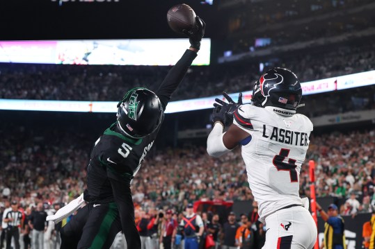 Oct 31, 2024; East Rutherford, New Jersey, USA; New York Jets wide receiver Garrett Wilson (5) catches a touchdown pass while being defended by Houston Texans cornerback Kamari Lassiter (4) during the second half at MetLife Stadium. Mandatory Credit: Ed Mulholland-Imagn Images