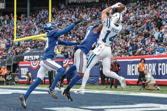 Dec 29, 2024; East Rutherford, New Jersey, USA; Indianapolis Colts wide receiver Alec Pierce (14) catches a touchdown pass as New York Giants safety Jason Pinnock (27) and cornerback Cor'Dale Flott (28) defend during the second half at MetLife Stadium. Mandatory Credit: Vincent Carchietta-Imagn Images