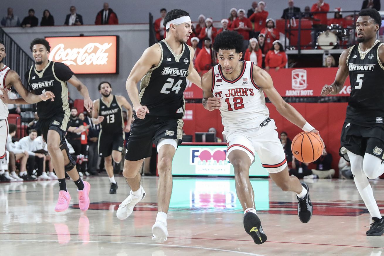 Dec 11, 2024; Queens, New York, USA; St. John’s Red Storm guard RJ Luis Jr. (12) looks to drive past Bryant University Bulldogs guard Rafael Pinzon (24) in the second half at Carnesecca Arena. Mandatory Credit: Wendell Cruz-Imagn Images