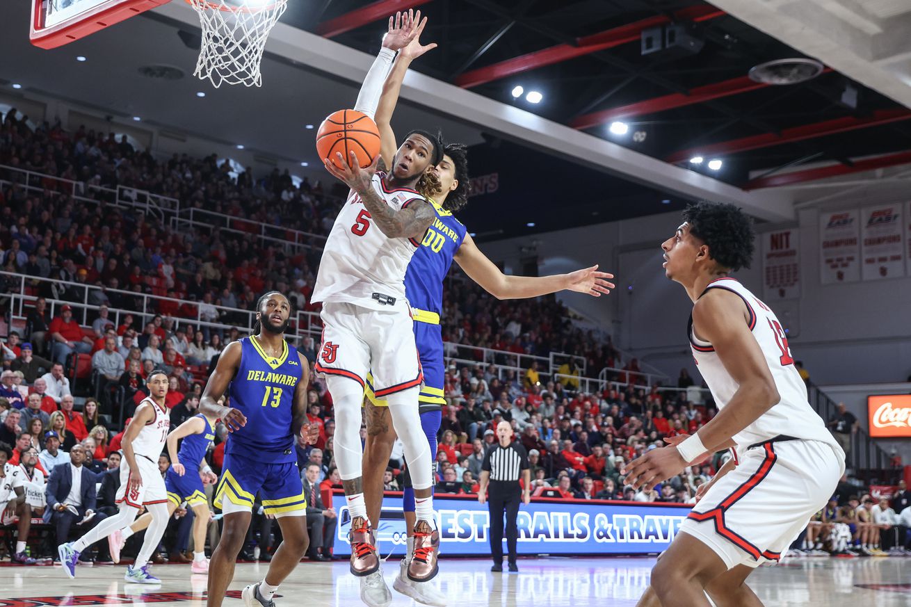 Queens, New York, USA; St. John’s Red Storm guard Deivon Smith (5) jumps in front of Delaware Fightin Blue Hens forward Gabe Moss (00) to grab a rebound in the first half at Carnesecca Arena. Mandatory Credit: Wendell Cruz-Imagn Images