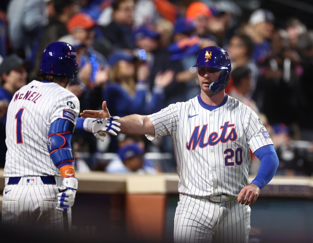 Oct 18, 2024; New York City, New York, USA; New York Mets first baseman Pete Alonso (20) celebrates scoring on an RBI from right fielder Starling Marte (6, not pictured) with New York Mets second baseman Jeff McNeil (1) during the eighth inning against the Los Angeles Dodgers during game five of the NLCS for the 2024 MLB playoffs at Citi Field. Mandatory Credit: Vincent Carchietta-Imagn Images