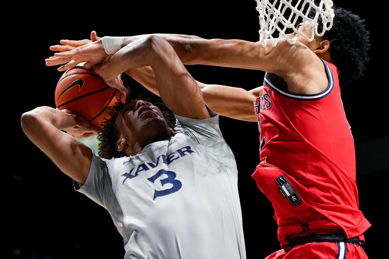 St. John’s Red Storm guard RJ Luis Jr. (12) blocks Xavier Musketeers guard Dailyn Swain (3) under the basket in the second half of the NCAA Big East Conference game between the Xavier Musketeers and the St. John’s Red Storm at the Cintas Center on the campus of Xavier University in Cincinnati on Tuesday, Jan. 7, 2025. St. John’s won 82-72.