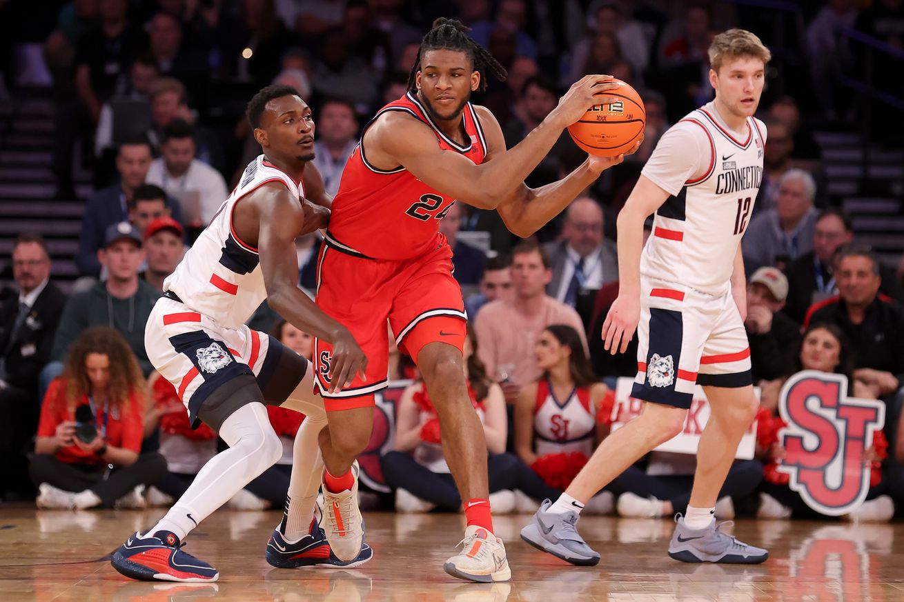 Mar 15, 2024; New York City, NY, USA; St. John’s Red Storm forward Zuby Ejiofor (24) controls the ball against Connecticut Huskies forward Samson Johnson (35) and guard Cam Spencer (12) during the second half at Madison Square Garden. Mandatory Credit: Brad Penner-Imagn Images